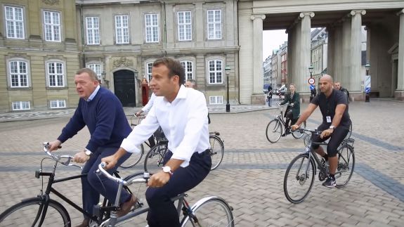 VIDEO. Fără geamuri umbrite și bodyguarzi cu serviete. Cum premierul Danemarcei i-a arătat președintelui francez Copenhaga